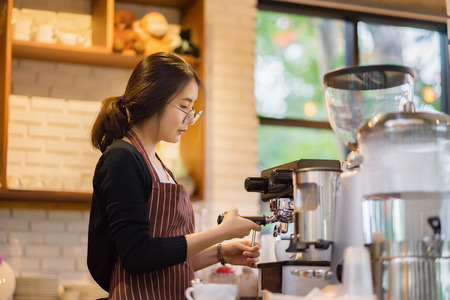 barista woman making latte art at coffee shop,equipment, coffee shop,cafeteria people and technology conceptの写真素材