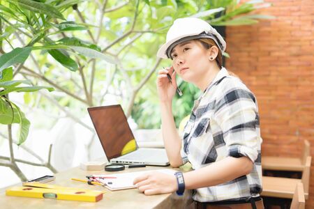 beautiful Asian woman civil engineer close up portrait on workplace,thinking about her project,...