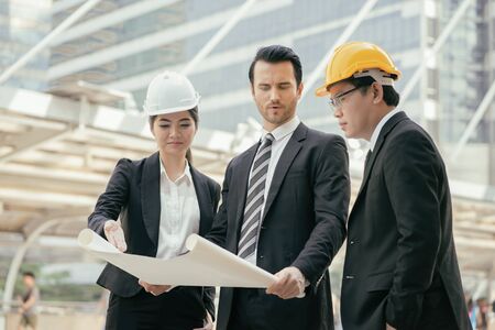 Engineering and architecture concept,engineers working on a building site holding a...