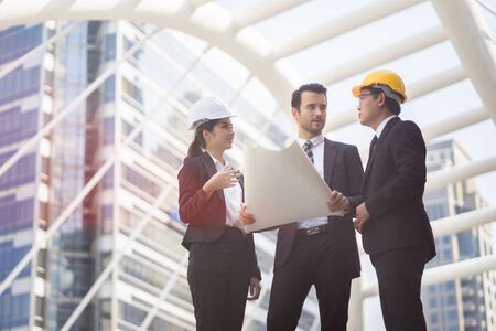 Engineering and architecture concept,engineers working on a building site holding a blueprints,architect man working  with engineer women inspection in workplace for architectural planの写真素材
