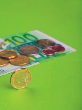 One hundred Euro bill and coins on the paperの写真素材