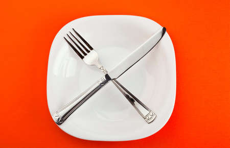 white plate with fork and knife on paperの写真素材