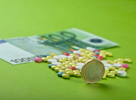 Pills and tablets with Euro bill and coinの写真素材