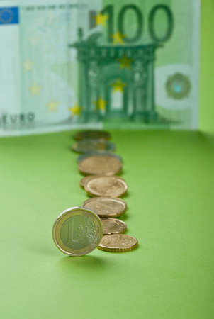 One hundred Euro bill and coins on the paperの写真素材