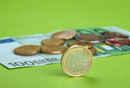 One hundred Euro bill and coins on the paperの写真素材