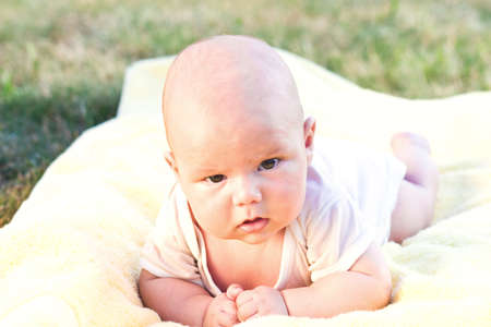 Cute baby boy lying on her belly in a yellow towelの写真素材