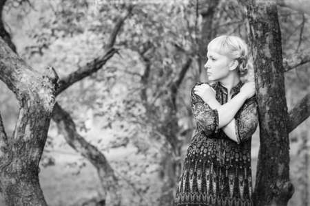 beautiful  young girl sitting on a tree branchの写真素材