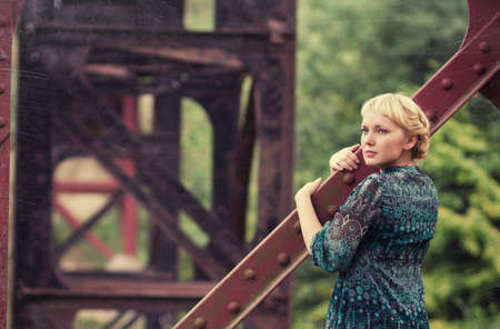 beautiful young caucasian girl standing on bridge bearingの写真素材