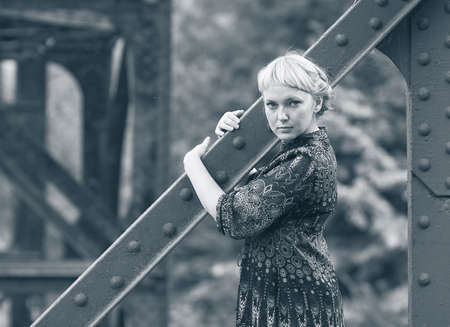 beautiful young caucasian girl standing on bridge bearingの写真素材
