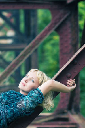 beautiful young caucasian girl is on bridge bearingの写真素材