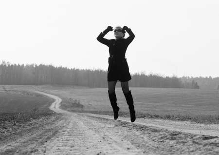 woman jumping on the road against the sky