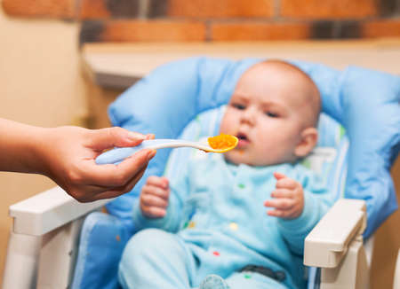 Portrait of cute baby boy while mother feedingの写真素材
