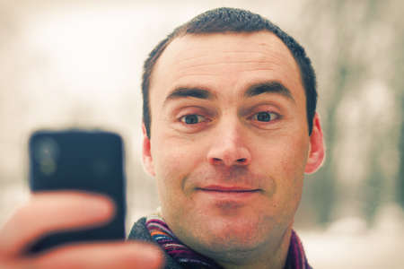 Man expresses emotion when talking on a cell mobile phoneの写真素材