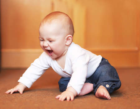 angry little kid boy sitting on the floorの写真素材