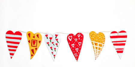 garland of homemade wooden hearts in whiteの写真素材