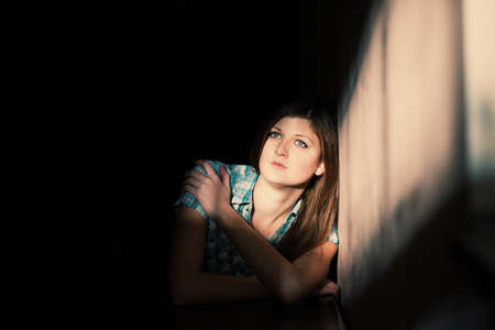 Young woman suffering from a severe depression in a line of lightの写真素材