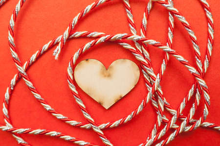 wood heart with gift ribbon on red paper