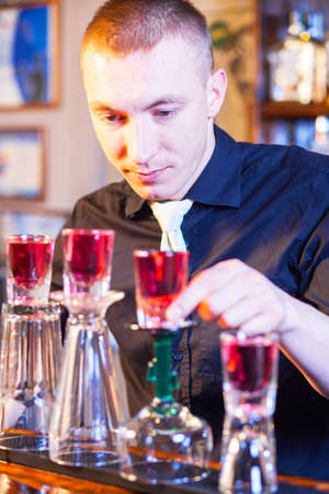 Young professional barman in action making cocktail drinksの写真素材