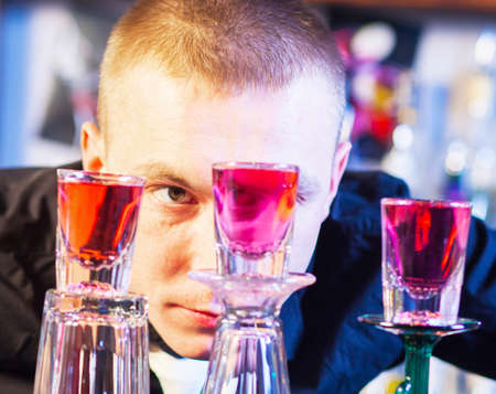 Young professional barman in action making cocktail drinks