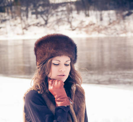 Portrait of a beautiful girl in a fur hatの写真素材