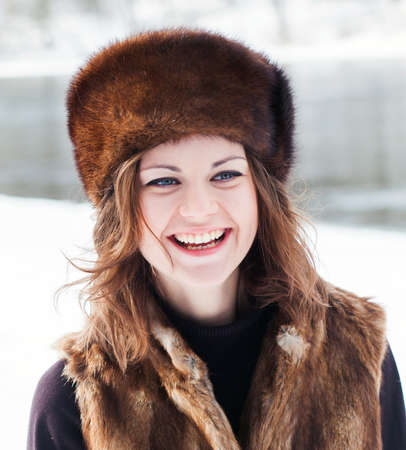 Portrait of a beautiful girl in a fur hatの写真素材