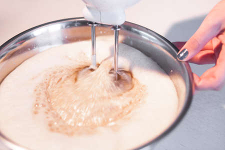 Mixing  egg cream in bowl with motor mixer, baking cakeの写真素材