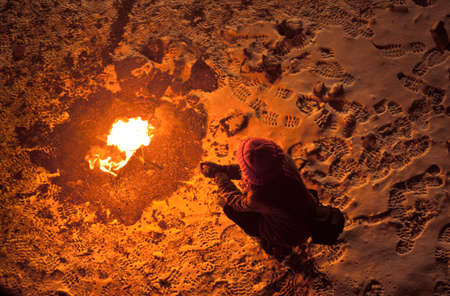 sad woman sitting near the bonfire at night
