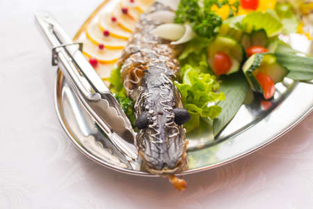 Stuffed pike decorated with vegetables and the greens. Very beautiful restaurant dish.の写真素材