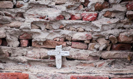 old stone cross on the wall in retro design.の写真素材