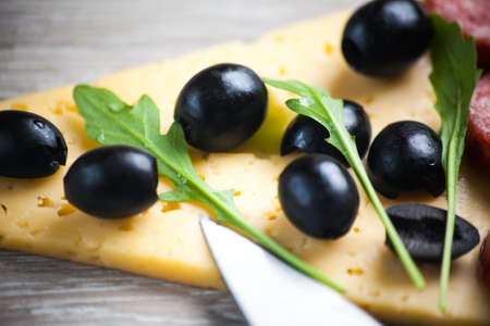Creative composition of ingredients salami, arugula, olives in the form of a slice of pizza.の写真素材