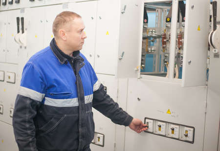 SHUCHIN, BELARUS - JANUARY 26 2015. Professional electrician installing components in electrical shieldのeditorial素材