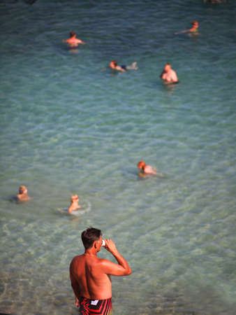 DIDIM, TURKEY - JULY 9 2014. a man drinking coffee on the seaのeditorial素材