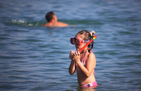 DIDIM, TURKEY - JULY 9 2014. Girl playing with toys on the sea.のeditorial素材