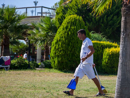 DIDIM, TURKEY - JULY 9, 2014. Hotel cleaner comes with tools for the lawn.のeditorial素材