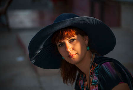 Beautiful young woman in a hat outdoors.の写真素材
