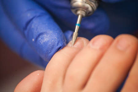 master pedicurist makes a pedicure female legs.の写真素材