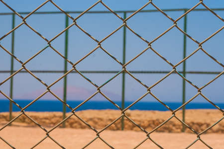 In the foreground is the grid, in the background the sea.の写真素材