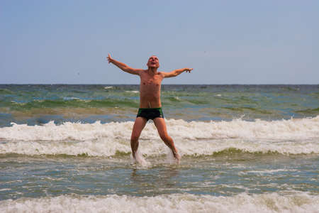 The happy young man jumping in the sea,