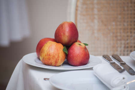 Red apples in a plate on white tableの写真素材
