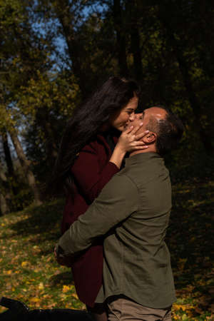 Beautiful young couple in autumn forest on a sunny dayの写真素材