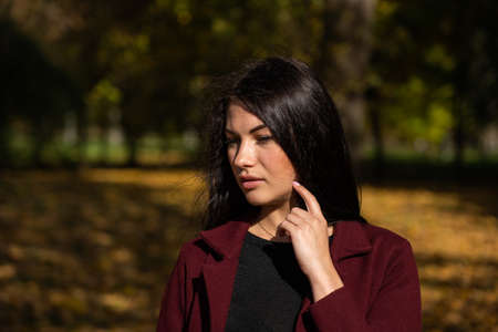 Beautiful young girl in the autumn forest on a sunny day