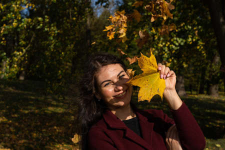 Beautiful young girl in the autumn forest on a sunny dayの写真素材