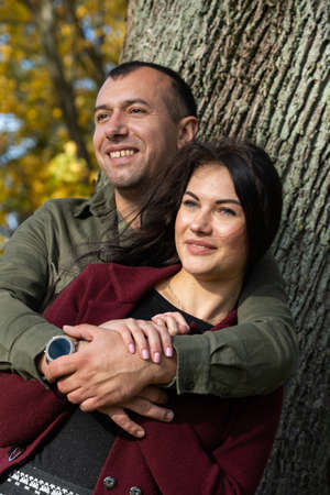 Beautiful young couple in autumn forest on a sunny dayの写真素材