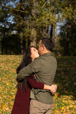 Beautiful young couple in autumn forest on a sunny dayの写真素材