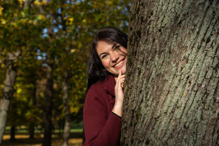 Beautiful young girl in the autumn forest on a sunny dayの写真素材