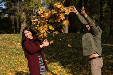 Beautiful young couple in autumn forest on a sunny dayの写真素材