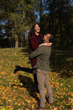 Beautiful young couple in autumn forest on a sunny dayの写真素材