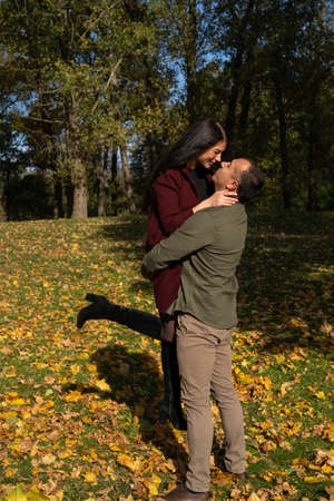 Beautiful young couple in autumn forest on a sunny dayの写真素材