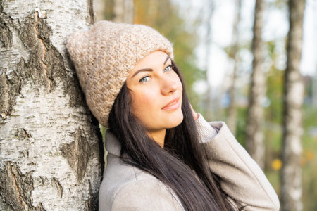 Beautiful young girl in the autumn forest on a sunny dayの写真素材