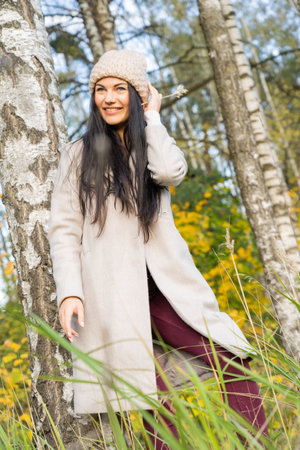 Beautiful young girl in the autumn forest on a sunny dayの写真素材
